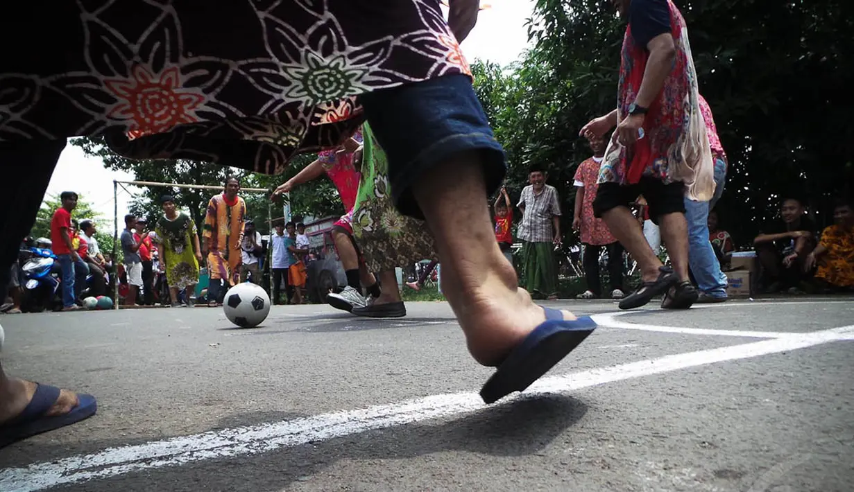 Para peserta yang mengenakan daster tampak saling berebut bola, Jakarta, Minggu (17/8/14). (Liputan6.com/Faizal Fanani)
