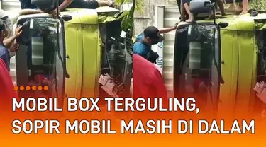 Sebuah mobil box terguling di jalan mengundang perhatian.