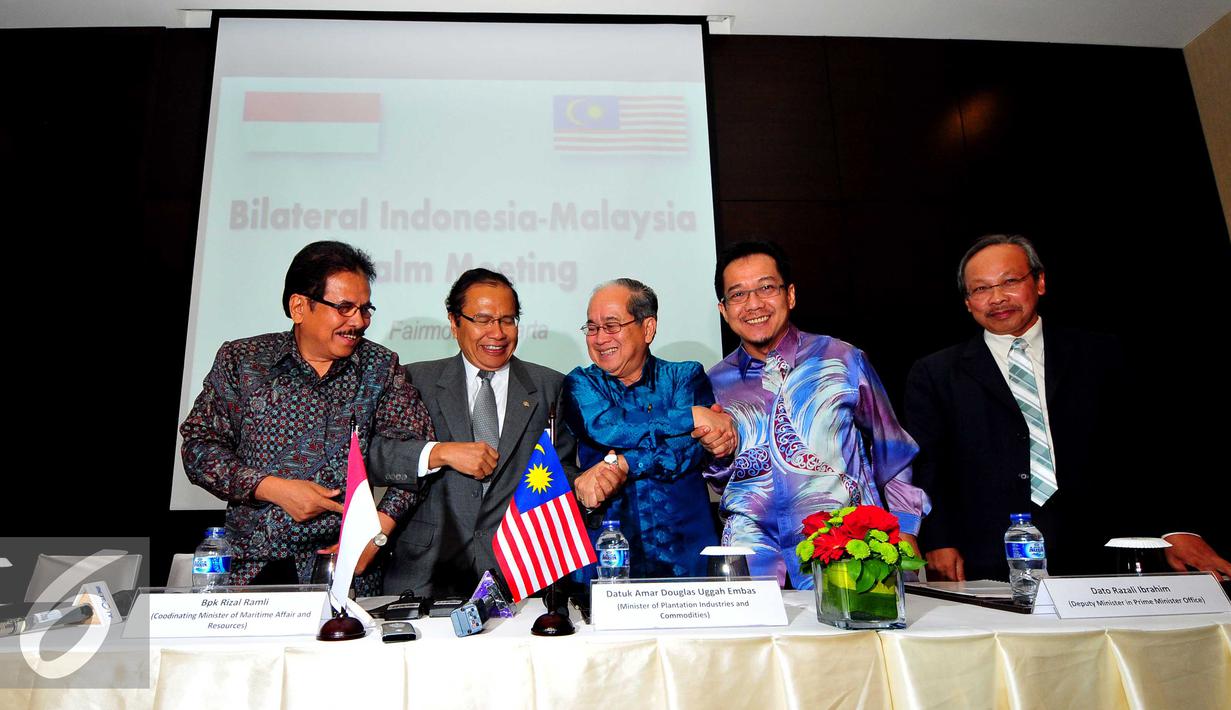 Menko Maritim, Rizal Ramli (kedua kiri) bersama Dato Douglas Unggah berjabat tangan usai konpres di Jakarta, Sabtu (3/10/2015). Pemerintah Indonesia bersama Pemerintah Malaysia sepakat membentuk organisasi kelapa sawit. (Liputan6.com/Helmi Afandi)