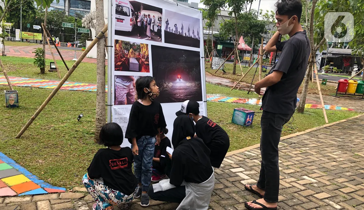 Komunitas “Kelas Jurnalis Cilik” dipandu pewarta foto mengikuti kegiatan tur pameran fotografi bertema 'Ragam Cerita Ibu Kota Sebelum dan Saat Pandemi COVID-19' di Thamrin 10, Jakarta, Minggu (6/12/2020). Pameran diselenggarakan oleh Pewarta Foto Indonesia - Jakarta. (Liputan6.com/Immanuel Anton