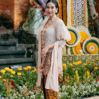 Happy Salma mengenakan kebaya transparan yang memiliki bordiran. Ia memadukannya dengan selendang dan bawahan kain coklatnya. [@happysalma]