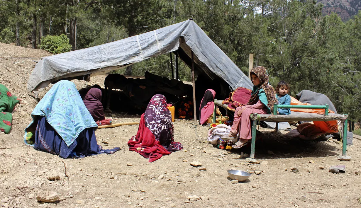 Penduduk desa duduk di luar tenda setelah rumah mereka rusak akibat gempa bumi di Distrik Spera, bagian barat daya Provinsi Khost, Afghanistan, 22 Juni 2022. Pejabat Taliban mengaku negaranya kesulitan sebab masih terkena sanksi. (AP Photo)