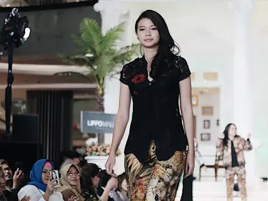 Penampilan Yuki saat berjalan di atas panggung catwalk mengenakan kebaya kutu baru hitam dengan kombinasi celana bermotif. (Liputan6.com/IG/@yukikt)