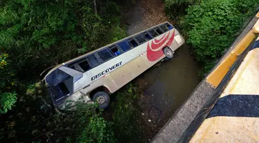Gambar bus yang terjun ke sungai dangkal dekat Tegucigalpa, Honduras, Selasa (5/12/2023). Kecelakaan menewaskan 13 orang dan melukai puluhan lainnya. (Johny MAGALLANES/AFP)