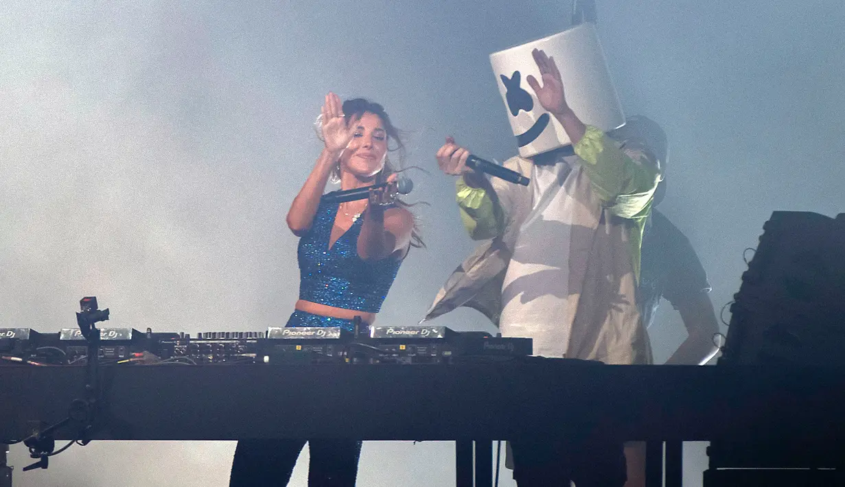 DJ sekaligus produser Amerika Serikat Marshmello (kanan) bersama bintang pop Lebanon Nancy Ajram membawakan single mereka "Sah Sah" pada seri konser Gamers8 di Riyadh, Arab Saudi, 11 Agustus 2022. Gamers8 adalah musim permainan besar-besaran yang berlangsung dari 14 Juli hingga 8 September di kerajaan gurun. (Nasser al-HARBI/AFP)