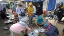 Pedagang ikan melayani pembeli di kawasan Pasar Sumur Jaya, Pandeglang, Banten, Sabtu (3/8/2019). Warga Kecamatan Sumur sebelumnya sempat mengungsi ke tempat lebih tinggi akibat gempa bermagnitudo 6,9 yang mengguncang Banten pada Jumat, 2 Agustus 2019 malam. (merdeka.com/Arie Basuki)