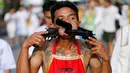 Seorang pemuja dari Kuil Samkong menusukkan dua revolver pada pipinya saat beratraksi dalam Festival Vegetarian di Phuket, Thailand, Selasa (4/10). Festival ini menampilkan aksi ekstrem pemuja dengan menusukkan benda tajam ke wajah. (REUTERS/Jorge Silva)