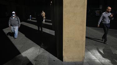 Seorang pejalan kaki memakai masker karena pandemi COVID-19 di pusat kota Santiago, Chile, Rabu (5/4/2022). Chile akan melonggarkan aturan protokol kesehatan Covid-19 pada 14 April dan berhenti mewajibkan penggunaan masker di ruang terbuka. (AP Photo/Esteban Felix)