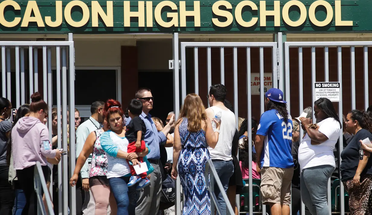 Orang tua dan keluarga menjemput anak mereka dari SMA Cajon setelah insiden penembakan di Sekolah Dasar North Park di San Bernardino, California, Senin (10/4). Dua orang termasuk seorang guru, tewas dalam penembakan di sekolah dasar (AP Photo/Jae C. Hong)