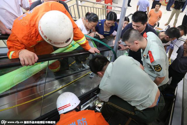 Petugas berusaha menyelamatkan balita tiga tahun dari jepitan eskalator | Photo: Copyright shanghaiist.com
