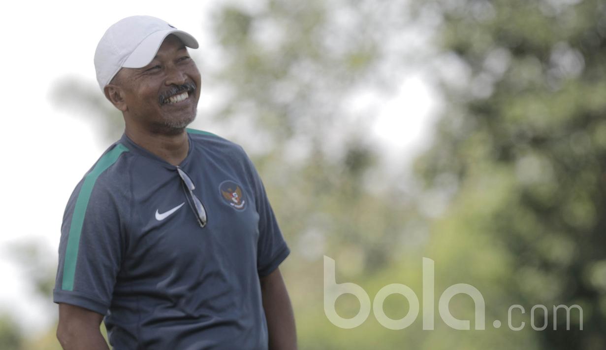 Pelatih Timnas Indonesia U-16, Fachri Husaini, tersenyum saat menyaksikan latihan pemain Timnas Indonesia U-16. Salah satu prestasi Fachri Husaini adalah meraih Medali perak SEA Games 1997 bersama timnas Indonesia.(Bola.com/M Iqbal Ichsan)