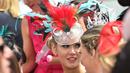 Wanita memakai hiasan kepala dari berbagai macam bulu saat menghadiri balap kuda Melbourne di arena pacuan kuda Flemington Racecourse, Australia (1/11). Flemington merupakan arena pacuan kuda sekaligus tempat hiburan kelas dunia. (AFP/Paul Crock)
