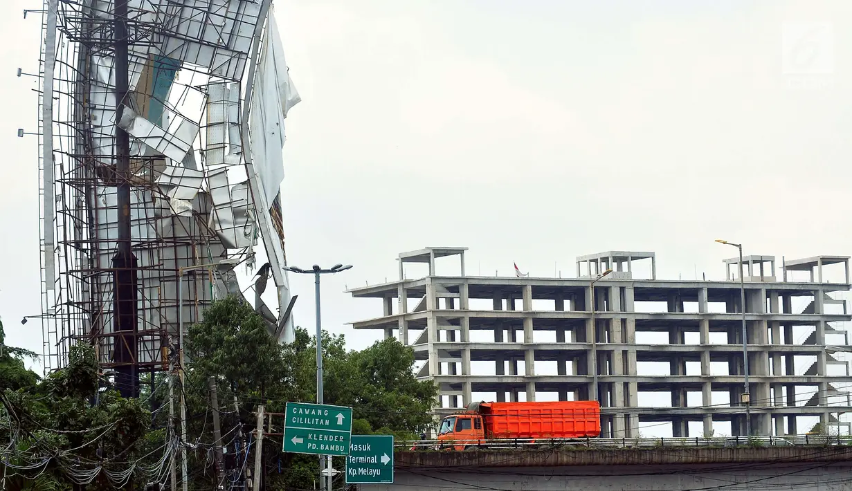 Sebuah papan reklame di kawasan Terminal Kampung Melayu hampir roboh, Jakarta, Senin (2/10). Hujan deras disertai angin kencang yang mengguyur Ibu Kota kemarin membuat papan reklame ini hampir roboh.(Liputan6.com/Helmi Afandi)