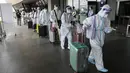 Penumpang asing yang mengenakan pakaian pelindung berjalan untuk penerbangan mereka ke China di Bandara Internasional Manila, Filipina, Senin (18/1/2021). Infeksi virus corona COVID-19 di Filipina telah melonjak melewati 500 ribu kasus.  (AP Photo/Aaron Favila)