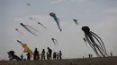 Orang-orang mengambil bagian dalam Varvara Kite Fest di Desa Varvara, pesisir Laut Hitam, Bulgaria, Jumat (27/8/2021). Penyelenggara Varvara Kite Fest Andrey Kulev mengatakan bahwa menerbangkan layang-layang seperti melepaskan semua masalah Anda di langit. (AP Photo/Valentina Petrova)