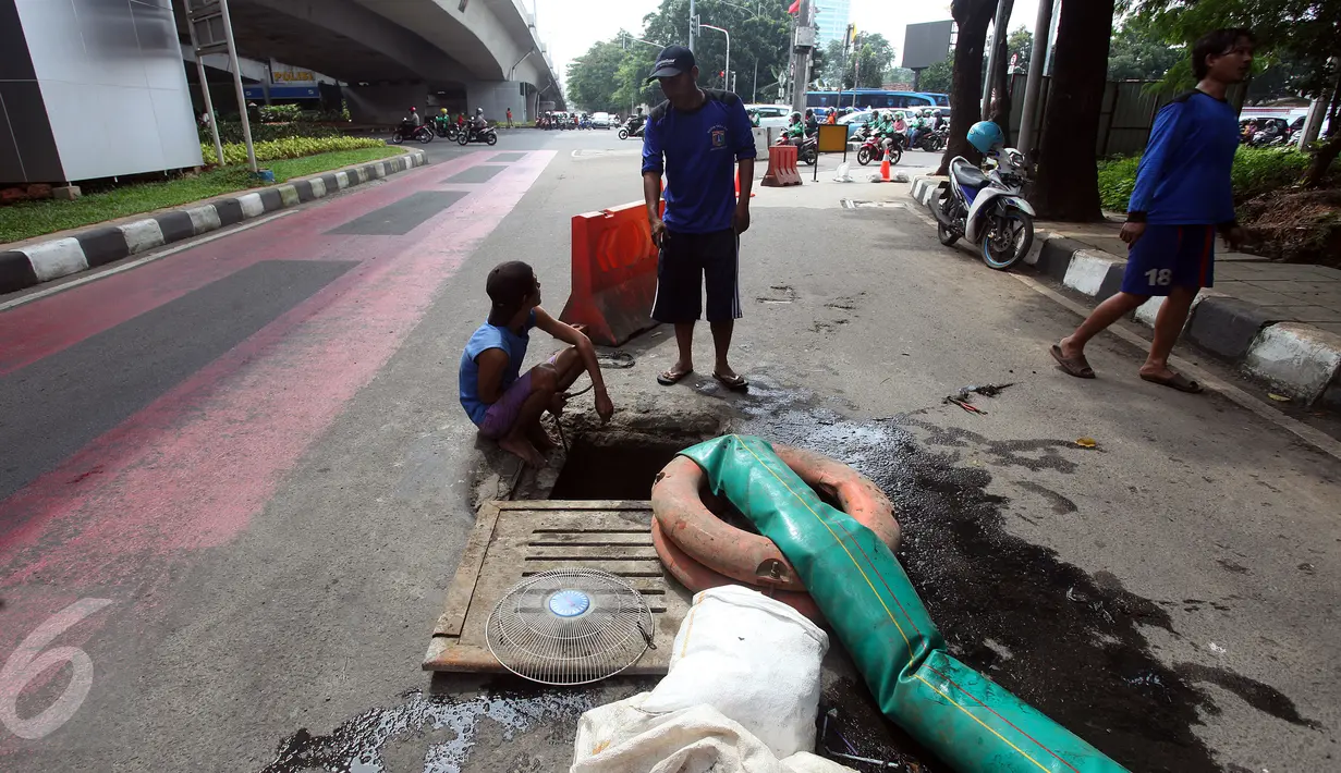 Petugas PPSU dan Dinas Sumber Daya Air (SDA) DKI menyisir kulit kabel di gorong-gorong saluran air Jalan Gatot Subroto, Jakarta , Senin (6/3). Penyusuran terkait adanya kecurigaan keanehan sebab banjir di Gatot Subroto. (Liputan6.com/Johan Tallo)