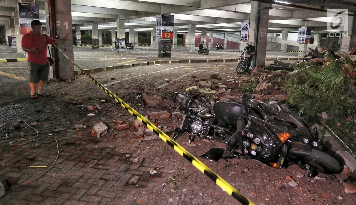 Kendaraan bermotor tertimbun reruntuhan bangunan parkir bertingkat akibat gempa di Mal Galeria, Ngurah Rai, Bali, Minggu malam (5/8). Gempa 7 SR sekitar 27 km Timur Laut Lombok Utara, NTB mengakibatkan bangunan parkir rusak. (Liputan6.com/Johan Tallo)