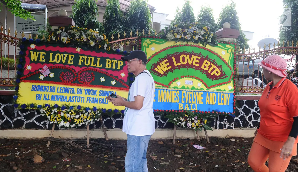Warga melihat karangan bunga jelang Basuki Tjahaja Purnama atau Ahok bebas di Mako Brimob, Kelapa Dua Depok, Kamis (24/1). Dalam hitungan jam, Basuki Tjahaja Purnama atau Ahok akan segera menghirup udara bebas. (Liputan6.com/Herman Zakharia)