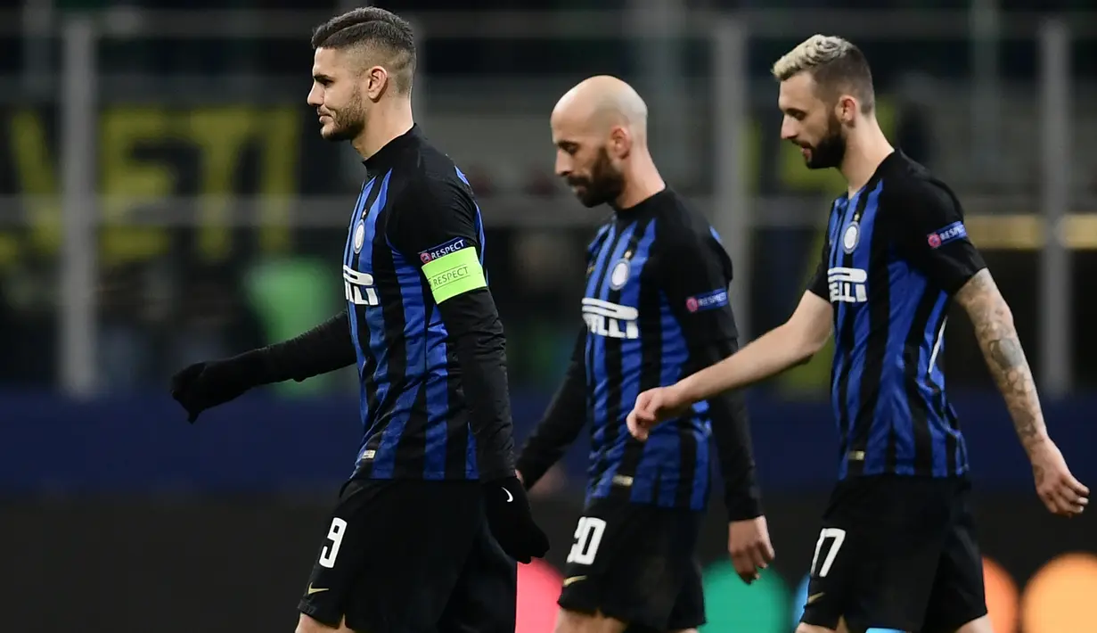 Pemain Inter Milan, Mauro Icardi, Borja Valero dan Marcelo Brozovic meninggalkan lapangan usai laga pamungkas penyisihan Grup B Liga Champions melawan PSV Eindhoven di Stadion San Siro, Rabu (12/12). Inter Milan bermain imbang 1-1. (Marco BERTORELLO/AFP)