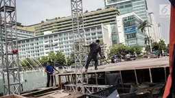 Pekerja menyelesaikan pembuatan panggung HUT ke-492 DKI di area Bundaran HI, Jakarta, Kamis (20/6/2019). Sejumlah artis Ibu Kota akan menghibur dalam peringatan HUT ke-492 DKI Jakarta. (Liputan6.com/Faizal Fanani)