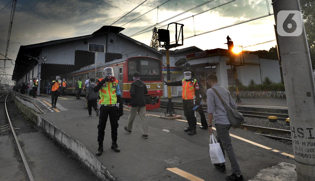 Petugas stasiun memandu penumpang KRL Commuterline di Stasiun Bogor, Jawa Barat, Selasa (9/6/2020) pagi. Puluhan polisi, TNI, Satpol PP, dan petugas stasiun diterjunkan untuk memandu penumpang mengantisipasi antrean panjang seperti kemarin. (merdeka.com/Arie Basuki)