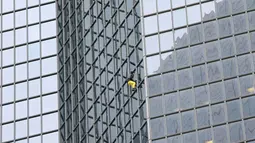 Pemanjat gedung, Alain Robert beraksi memanjat gedung tanpa alat bantu di pusat bisnis La Defense, Paris, Prancis, Senin (21/3/2016). Pria yang dijuluki 'Spiderman' ini telah memanjat lebih dari 70 gedung tertinggi di dunia. (Jacques DEMARTHON/AFP)