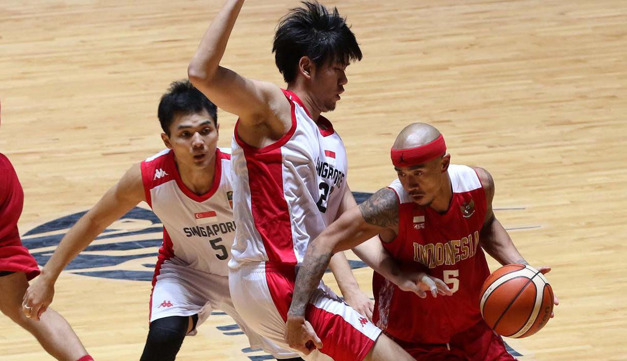 Pebasket putra Indonesia, Mario Wuysang (kanan), berusaha melewati hadangan pemain Singapura dalam semi final basket SEA Games 2015. (Bola.com/Arief Bagus)