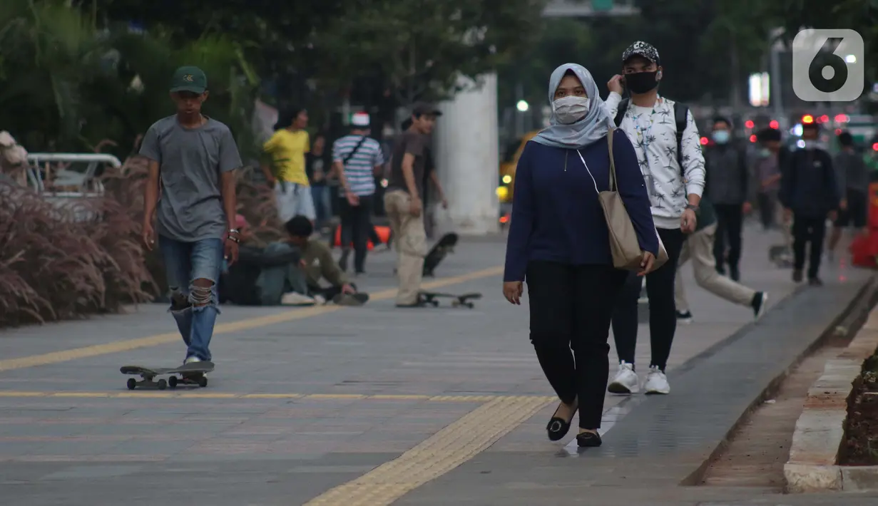 Pejalan kaki menggunakan masker di trotoar Jalan Jenderal Sudirman, Jakarta, Rabu (27/5/2020). Pemerintah akan mengerahkan personel TNI/Polri guna memastikan masyarakat menerapkan protokol kesehatan diantaranya menggunakan masker, jaga jarak, dan hindari kerumunan. (Liputan6.com/Helmi Fithriansyah)
