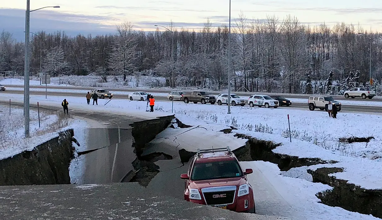 Satu mobil terperangkap di jalan Minnesota Drive yang amblas menyusul gempa bumi di Anchorage, Alaska, Jumat (30/11). Sebagian besar jalan layang di dekat bandara Anchorage runtuh, menjebak sebuah mobil di beton yang hancur. (AP Photo/Dan Joling)