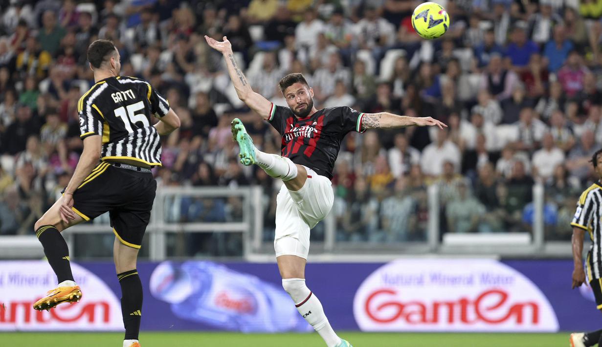 Striker AC Milan, Olivier Giroud (kanan) berusaha menjangkau bola di bawah penjagaan bek Juventus, Federico Gatti pada laga pekan ke-37 Liga Italia 2022/2023 di Allianz Stadium, Turin, Senin (29/5/2023) dini hari WIB. (LaPresse via AP Photo/Tano Pecoraro)