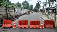 Pekerja Suku Dinas Bina Marga Jakarta Utara menyelesaikan perbaikan jalan jelang gelaran balap liar legal di Jalan Inspeksi Kali Ancol, Pademangan, Rabu (12/1/2022). Polda Metro Jaya resmi menjadikan Jalan Inspeksi Kali Ancol sebagai arena balap liar legal. (merdeka.com/Iqbal S. Nugroho)