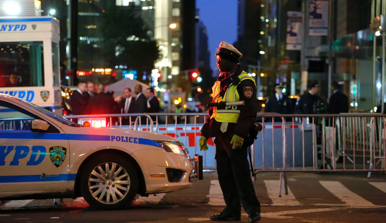Seorang polisi berjaga di luar Trump Tower di 5th Avenue, New York, Kamis (10/11). Seiring munculnya gelombang unjuk rasa anti Trump, markas Presiden terpilih AS itu kini dijaga ketat sejumlah personel Departemen Kepolisian New York. (KENA BETANCUR/AFP)