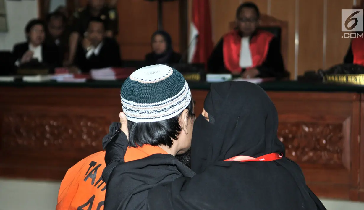 Terdakwa kasus terorisme Wawan Kurniawan dicium istrinya sebelum sidang vonis terkait kasus penyerangan kantor polisi, pembuatan bom dan pelatihan semi militer di Kabupaten Kampar, Riau di PN Jakarta Barat, Kamis (13/9). (Merdeka.com/Iqbal S. Nugroho)