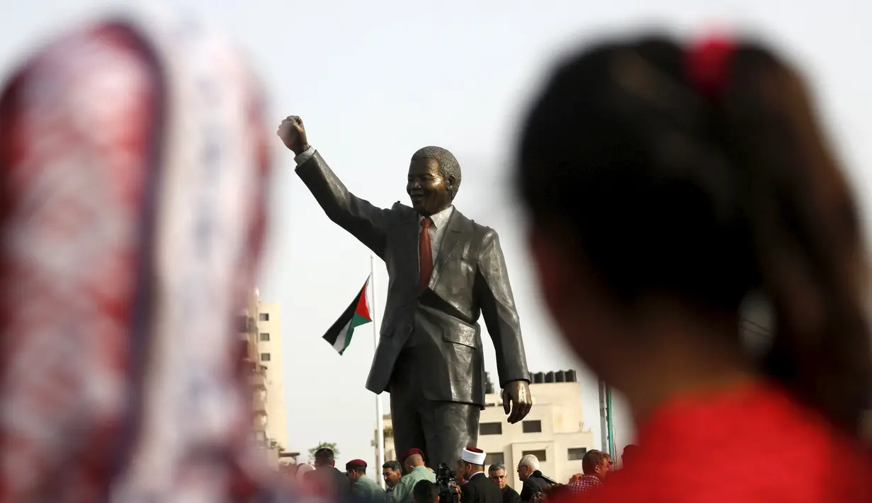 Warga menghadiri peresmian patung Nelson Mandela saat peresmian di kota Ramallah, Tepi Barat, Selasa (26/4). Patung perunggu tersebut merupakan hadiah dari Johannesburg, ibukota Afrika Selatan, untuk bangsa Palestina. (REUTERS/Mohamad Torokman)