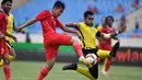 Gelandang Timnas Indonesia U-23, Witan Sulaeman berebut bola dengan bek Malaysia, Harith Haiqal bin Adam Afkar dalam pertandingan perebutan medali perunggu SEA Games 2021 di Stadion My Dinh, Minggu (22/5/2022). Indonesia ditahan imbang 1-1 dan menang 4-3 di adu penalti. (AFP/Ye Aung Thu)