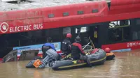 Tim penyelamat melakukan operasi pencarian di sepanjang jalan yang terendam banjir menuju terowongan bawah tanah di Cheongju, Korea Selatan, 16 Juli 2023. Hujan deras berhari-hari memicu banjir bandang dan tanah longsor serta menghancurkan rumah, menyebabkan puluhan orang tewas dan memaksa ribuan orang untuk mengungsi. (Kim Ju-hyung/Yonhap via AP)