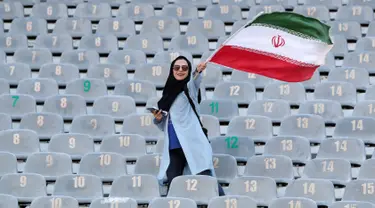 Wanita Iran mengibarkan bendera negaranya saat akan menyaksikan laga kualifikasi Piala Dunia 2022 antara Iran dengan Kamboja di Stadion Azadi, Teheran, Iran, Kamis (10/10/2019). Wanita Iran akhirnya diizinkan menonton bola dalam stadion setelah 38 tahun dilarang. (AP Photo/Vahid Salemi)