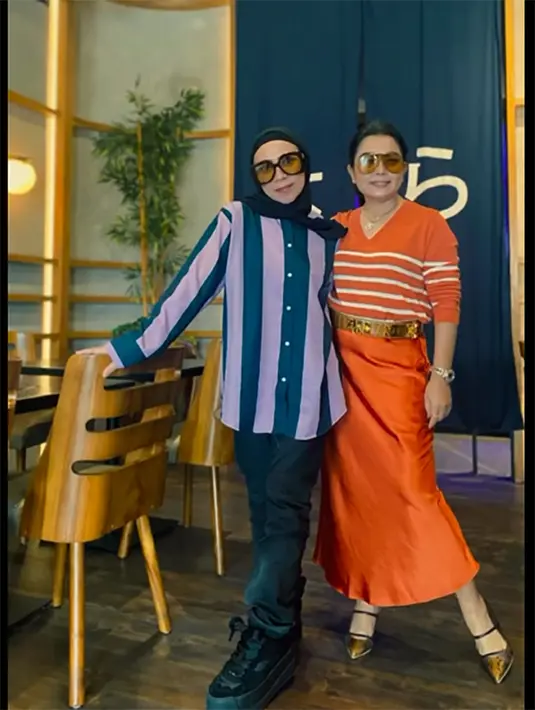 Meski mengenakan outfit yang berbeda-beda warna dan model, tapi kalau dilihat kompak dengan motif garis-garis. [Instagram/melly_goeslaw]