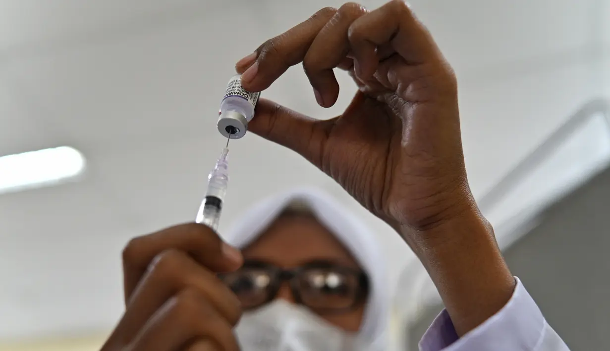 Seorang petugas kesehatan menyiapkan dosis vaksin virus corona COVID-19 Pfizer di Rumah Sakit Zainoel Abidin, Banda Aceh, Aceh, Selasa (9/11/2021). Vaksinasi COVID-19 di kalangan warga Kota Banda Aceh tembus 80 persen. (CHAIDEER MAHYUDDIN/AFP)