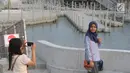 Warga berfoto-foto di kawasan pedestrian Kali Besar, Kota Tua, Jakarta, Rabu (11/7). Proyek revitalisasi Kali Besar itu telah diresmikan dan dibuka untuk umum oleh Wakil Gubernur Sandiaga Uno akhir pekan lalu. (Liputan6.com/Arya Manggala)