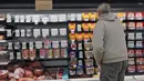 Pembeli di toko grosir di Pittsburgh melihat tampilan daging sarapan yang sebagian kosong, Selasa (11/1/2022). Varian Omicron yang sangat menular menciptakan kekurangan tenaga kerja yang memengaruhi pengiriman produk dan pengisian kembali rak-rak toko di seluruh negeri. (AP Photo/Gene J. Puskar)