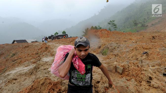 Warga korban longsor menyelamatkan barang-barang miliknya di Dusun Cimapag, Desa Sirnaresmi, Kecamatan Cisolok, Sukabumi, Selasa (1/1). Longsor mengakibatkan 30 rumah yang dihuni 107 jiwa tertimbun pada 31 Desember 2018. (merdeka.com/Arie Basuki)