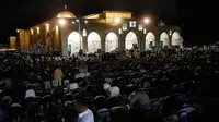 Muslim Palestina memanjatkan doa sambil menunggu Lailatul Qadar di luar Dome of the Rock, kompleks masjid Al-Aqsa di Kota Tua Yerusalem, Senin (11/6).Malam Lailatul Qadar juga disebut malam yang lebih baik daripada malam seribu bulan. (AFP/AHMAD GHARABLI)