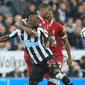 Pemain Newcastle United, Christian Atsu (kiri) berebut bola dengan pemain Liverpool, Georginio Wijnaldum pada lanjutan Premier League di St James Park, Newcastle, (1/10/2017). Liverpool bermain imbang 1-1. (AFP/Lindsey Parnaby)