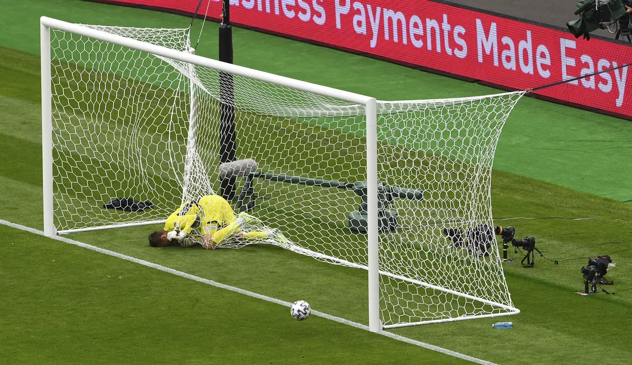 Kiper Skotlandia David Marshall tersangkut pada jaring gawang setelah gagal menyelamatkan tendangan jarak jauh pemain Republik Ceko Patrik Schick pada pertandingan Grup D Euro 2020 di Stadion Hampden Park, Glasgow, Inggris, Senin (14/6/2021). (AP Photo/Andy Buchanan, Pool)