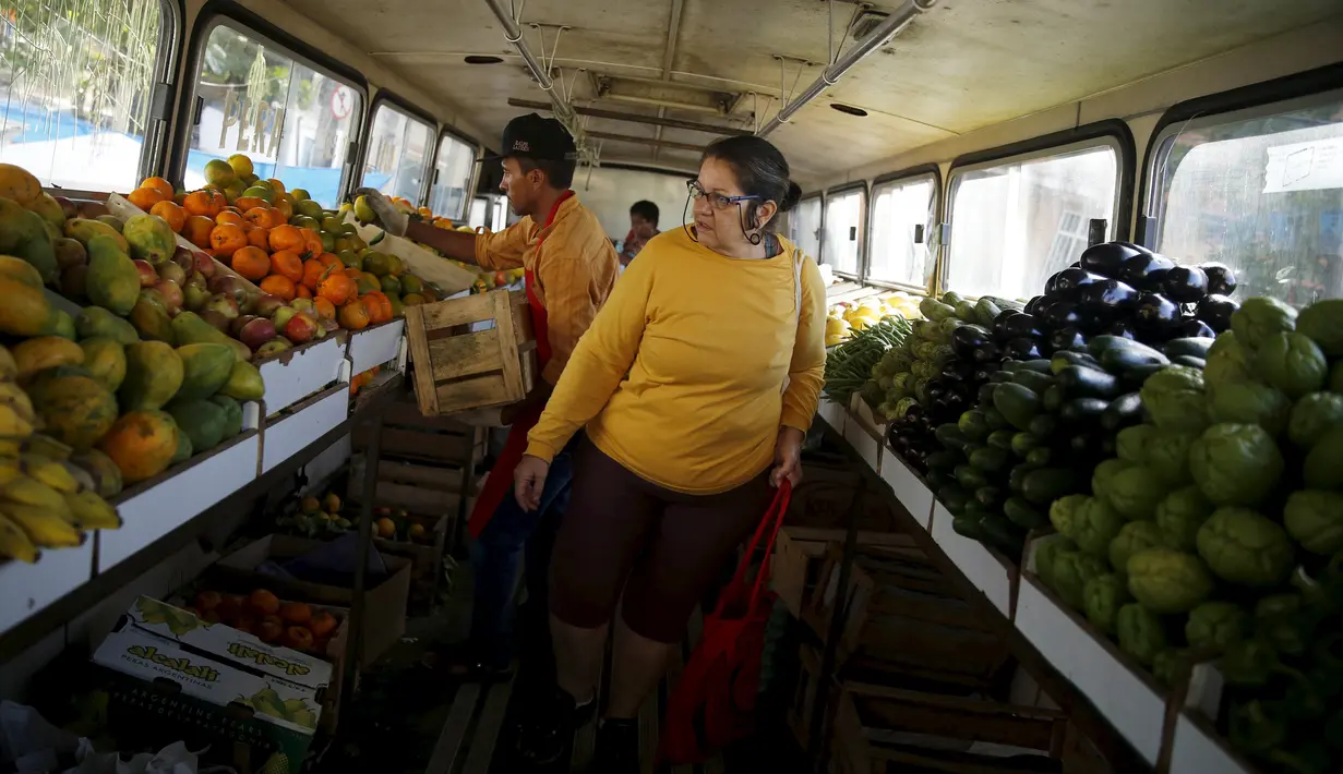 Seorang wanita mencari buah-buahan saat berbelanja di dalam pasar bus 'Sacolao' di Santa Teresa, Rio de Janeiro, Brasil, Selasa (7/7/2015). Pasar bus ini menjual sayur dan buah-buahan dengan harga yang terjangkau. (REUTERS/Pilar Olivares)