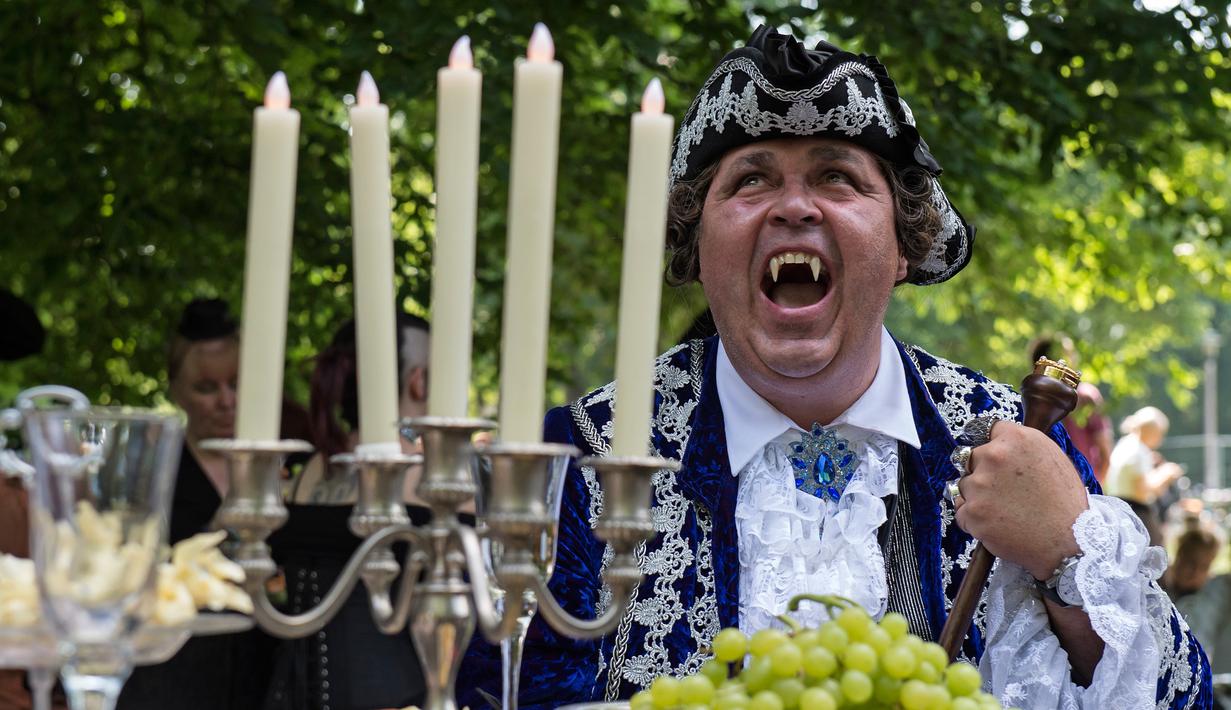 Seorang pria menunjukan gigi taringnya saat mengikuti Victorian Picnic selama festival Wave Gotik Treffen (WGT) di Leipzig, Jerman (6/2). (AP Photo/Jens Meyer)