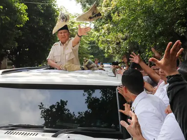 Presiden Republik Indonesia Prabowo Subianto menyapa warga sekaligus membagikan kaos seusai kunjungan dari Sekolah Dasar Negeri (SDN) Jati 03, Jakarta, Rabu (7/5/2025). (Liputan6.com/Herman Zakharia)