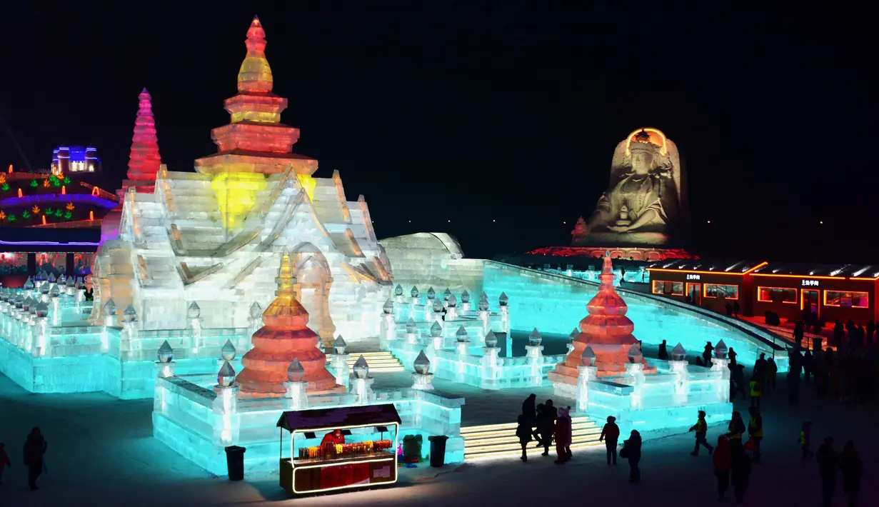 Sejumlah orang mengunjungi Harbin Ice-Snow World di Harbin di provinsi Heilongjiang, Tiongkok (2/1). Bangunan atau istana yang terbuat dari balok es ini dipenuhi cahaya yang berwarna-warni. (AFP Photo/China Out)