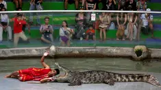 Seorang pria beratraksi dengan meletakkan kepalanya kedalam mulut buaya di Sriracha Tiger Zoo, Provinsi Chonburi , Thailand , 7 Juni 2016. Aksi nekat ini mengundang decak kagum wisatawan yang hadir. (REUTERS / Chaiwat Subprasom)